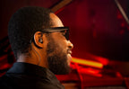 Beyerdynamic DT 73 IE in-ear studio headphones worn by musician Cory Henry, showcasing detailed earbud design and branding.