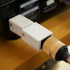 SilentPower DC Blocker+ noise filter displayed with a sleek design and connectors visible on a slate background.